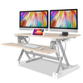 Load image into Gallery viewer, Fortia Desk Riser 90cm Wide Adjustable Sit to Stand for Dual Monitor, Keyboard, Laptop, Beech
